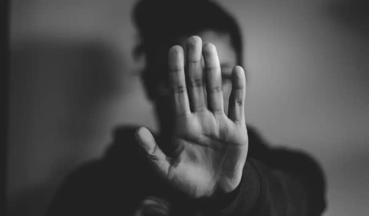 une personne qui brandit sa main pour dire stop